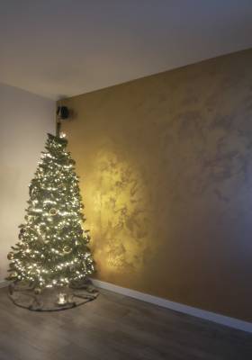 kerstboom met goud kleurige stucwand